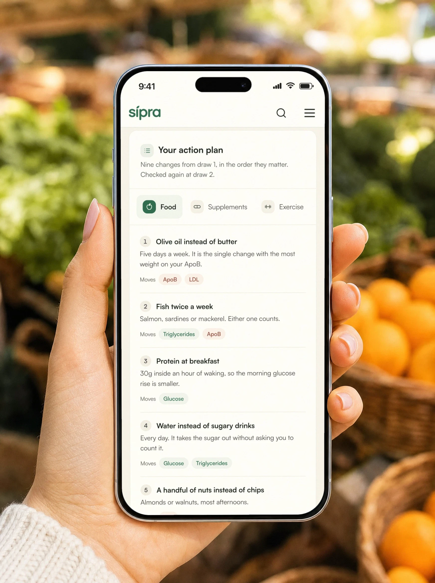 A member at the farmers market, her action plan open on her phone