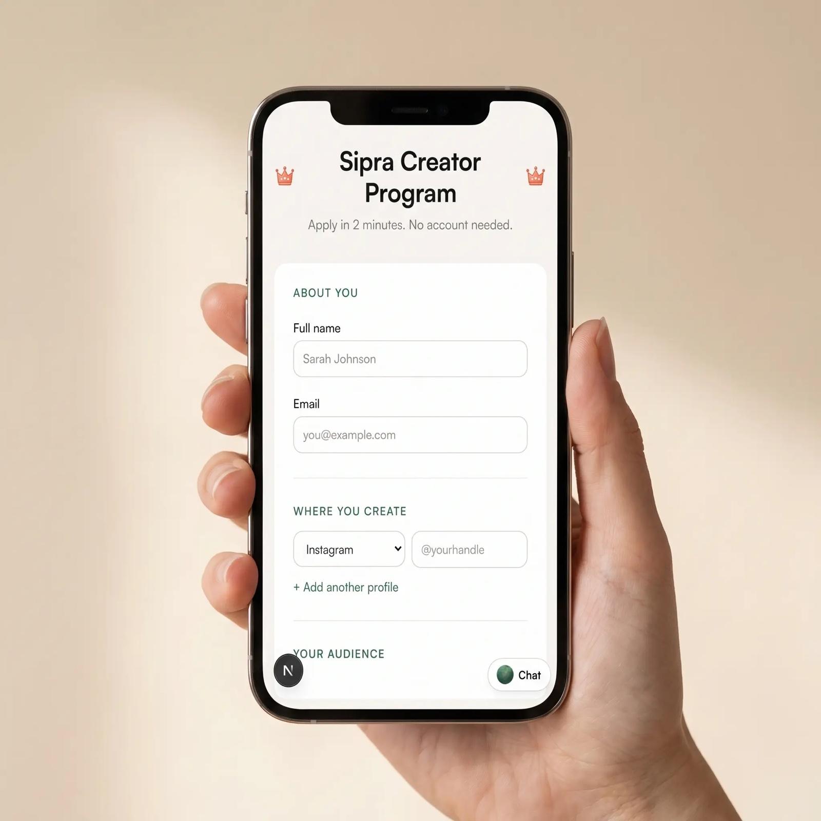 A creator holding a phone open to the Sipra Creator Program application